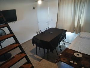 Habitación con mesa de comedor y cama en Los jilgeros, en Santa Rosa de Calamuchita