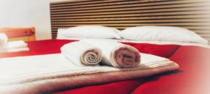 a bedroom with two beds with towels and pillows at La cas d' Taton in Pratola Peligna