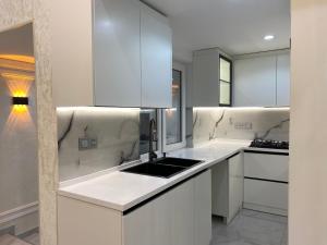 库巴House in Quba的带白色橱柜和水槽的白色厨房