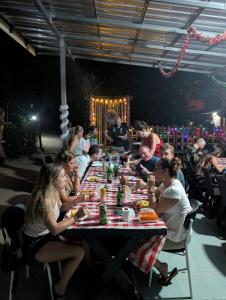 a group of people sitting at a long table at Hangover Chill & Hill Hostel in Phi Phi Islands +54 photos