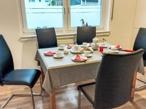 ein Tisch mit Stühlen und Tellern mit Essen darauf in der Unterkunft Apartment Lindenstraße-1 by Interhome in Wöbbel + 12 Fotos