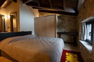 a bedroom with a large bed and a window at Eptalofos Mountain Resorts in Eptalofos