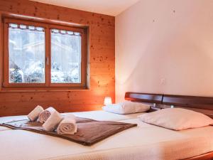 a bedroom with a large bed with towels on it at Apartment Moulin du Raé A2 by Interhome in Nendaz