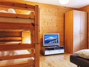 a bedroom with two bunk beds and a television at Apartment Moulin du Raé A2 by Interhome in Nendaz +22 photos