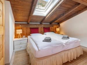 ein Schlafzimmer mit einem großen Bett mit Dachfenster in der Unterkunft Apartment Brissago Blue by Interhome in Brissago