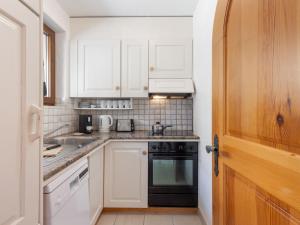 eine Küche mit weißen Schränken und einem schwarzen Backofen in der Unterkunft Apartment Brissago Blue by Interhome in Brissago