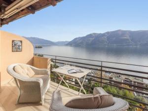 einen Balkon mit Stühlen und einem Tisch sowie Seeblick in der Unterkunft Apartment Brissago Blue by Interhome in Brissago