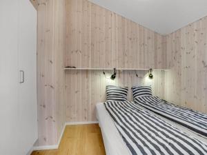 two beds in a room with wooden walls at Holiday Home Godja - 300m from the sea by Interhome in Torsted +27 photos