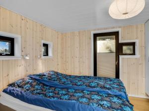 a bedroom with a bed with a blue comforter at Holiday Home Godja - 300m from the sea by Interhome in Torsted