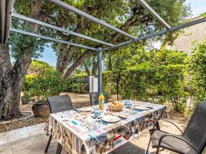 a table and chairs on a patio under a pergola at Holiday Home Les Parcs de Gassin-1 by Interhome in Saint-Tropez