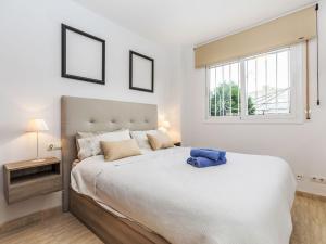Un dormitorio con una gran cama blanca y una ventana. en Apartment California by Interhome, en Miami Platja