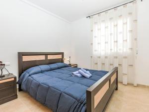 a bedroom with a large bed with a blue blanket at Holiday Home Llevant by Interhome in Creixell