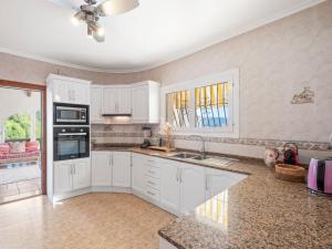 a kitchen with white cabinets and a sink at Villa Moraira Magica by Interhome in Moraira