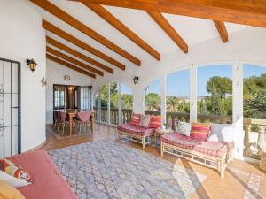 an open living room with red furniture and windows at Villa Moraira Magica by Interhome in Moraira