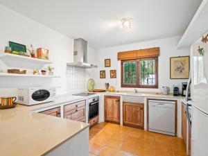 a kitchen with white appliances and wooden cabinets at Villa La Familia by Interhome in Benissa