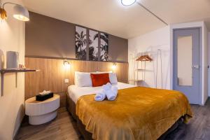 a hotel room with a large bed with towels on it at Hôtel Le Roxane in Bergerac