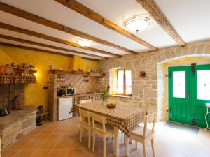 a kitchen with a table and a green door at Holiday Home Franz by Interhome in Potpićan