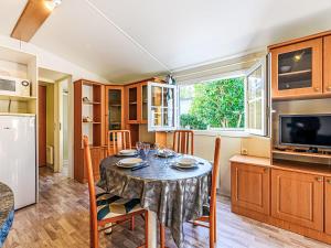 kuchnia ze stołem, krzesłami i lodówką w obiekcie Apartment La Spatule by Interhome w mieście Carnac