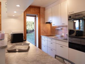 une cuisine avec des armoires blanches et un comptoir dans l'établissement Apartment Le Schuss 1 by Interhome, à Gryon