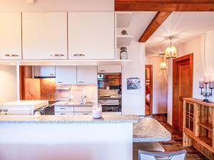 eine Küche mit weißen Schränken und einer Arbeitsplatte in der Unterkunft Apartment Le Schuss 1 by Interhome in Gryon