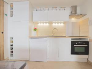 a kitchen with white cabinets and a sink at Holiday Home Les Sopralynes-2 by Interhome in Agde
