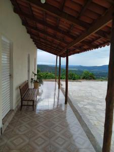 a porch with a bench sitting on top of a building at Recanto 3 Marias in Pirenópolis