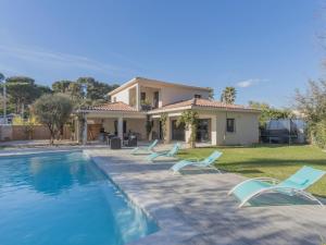 ein Haus mit einem Pool mit Stühlen und einem Haus in der Unterkunft Holiday Home Villa by Interhome in Les Lecques