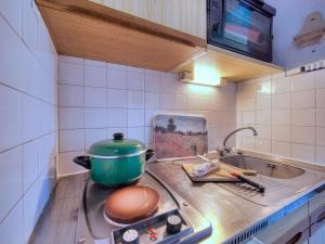 eine Küchentheke mit einem Topf auf dem Herd in der Unterkunft Studio Soyouz Vanguard-103 by Interhome in Le Corbier