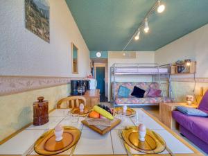 ein Wohnzimmer mit einem Tisch und einem Sofa in der Unterkunft Studio Soyouz Vanguard-103 by Interhome in Le Corbier + 31 Fotos