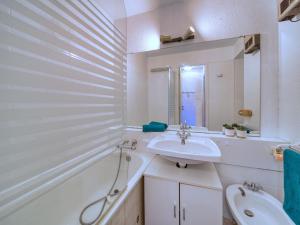 ein weißes Badezimmer mit Waschbecken und Badewanne in der Unterkunft Studio Soyouz Vanguard-103 by Interhome in Le Corbier