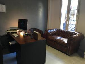 a office with a leather couch and a desk with a computer at Tipi in Paris
