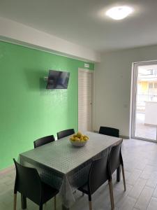 una mesa de comedor con un bol de fruta. en DonBà apartments, en Capo dʼOrlando 11 fotos más