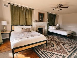 1 dormitorio con 2 camas y chimenea en Americana Manor, en Lubbock