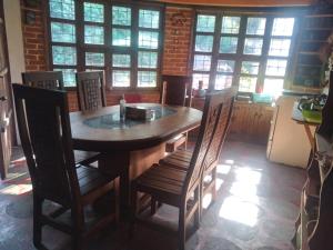 a dining room with a wooden table and chairs at Cabaña en el bosque-servicios limitados LEERLOS in El Carmen
