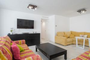 a living room with two couches and a flat screen tv at Torremolinos 5 Rooms Junto al Mar in Torremolinos