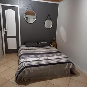 sypialnia z łóżkiem i lustrem na ścianie w obiekcie Chambre d'hôte indépendante près de la jalle w mieście Martignas-sur-Jalle