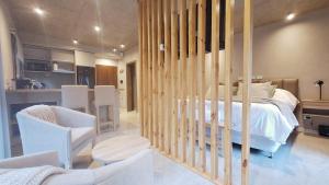 ein Schlafzimmer mit einem Bett und Stühlen sowie eine Küche in der Unterkunft Blizu II in Villa La Angostura