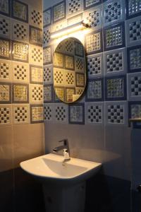 Un baño con un lavabo y un espejo en la pared. en Moody Moon Vagamon, en Vagamon