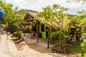 een groen huis met een tafel en stoelen ervoor bij Hospedagem Morro dos Muricis in Piuí +26 foto's