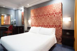 sypialnia z białym łóżkiem i czerwoną ścianą w obiekcie Hotel IMPERATORI w Rzymie +25 zdjęć