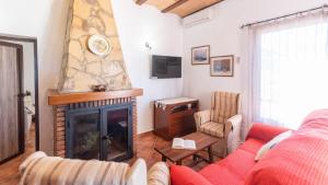 a living room with a red couch and a fireplace at La Roca del Gastor by Ruralidays in El Gastor