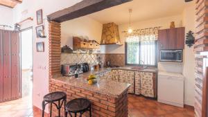 a kitchen with a counter and some chairs in it at La Roca del Gastor by Ruralidays in El Gastor