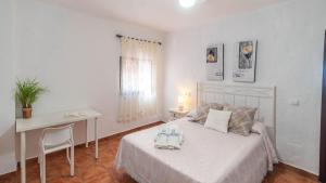 a bedroom with a bed and a desk and a table at La Roca del Gastor by Ruralidays in El Gastor +19 photos