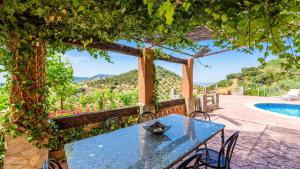 a blue table and chairs on a patio with a pool at La Roca del Gastor by Ruralidays in El Gastor