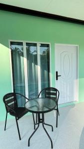 a glass table and two chairs on a patio at The zign in Ko Yao Yai