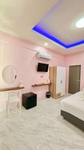 a room with pink walls and a bed and a table at The zign in Ko Yao Yai
