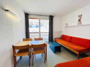 a living room with a table and a couch at Pause montagnarde in Le Dévoluy