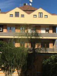 an apartment building with a balcony and trees at Holiday Dreams in Francavilla al Mare