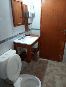 a bathroom with a toilet and a sink at Casita en las sierras in Huerta Grande +2 photos