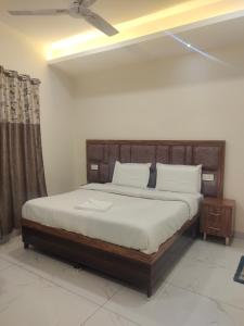 a bedroom with a large bed with white sheets and pillows at Hotel G-3 in Jalandhar